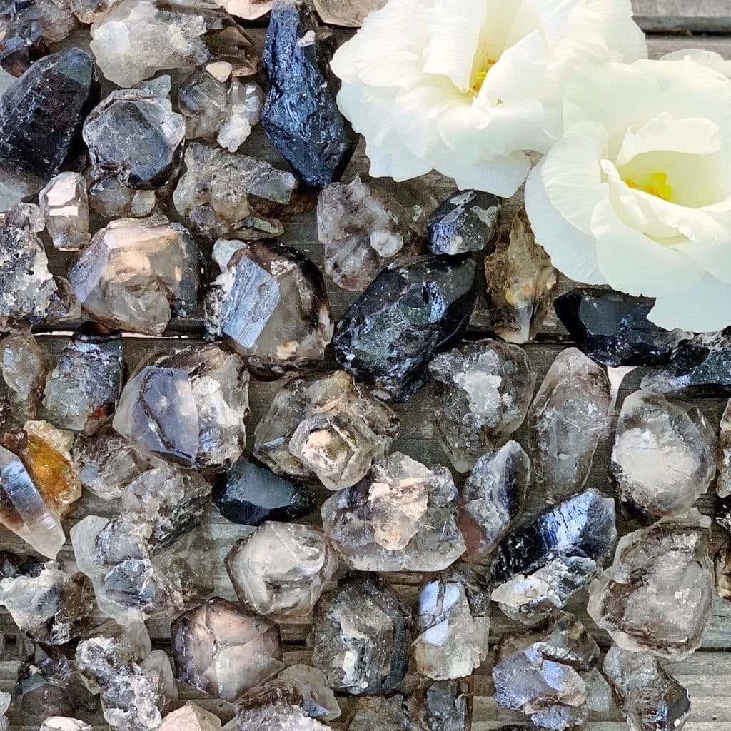 A bunch of crystals and flowers on a wooden surface.