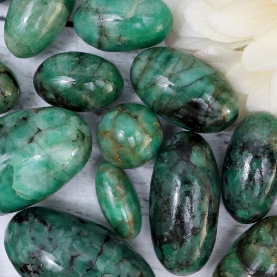 Green emerald stones on a white surface.