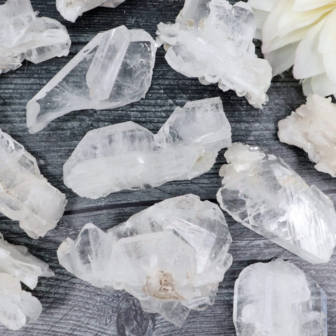 A bunch of white quartz crystals on a wooden table.