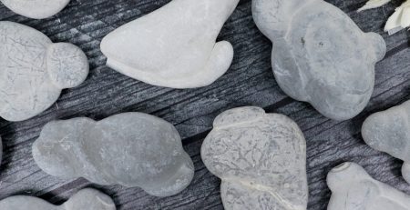 A bunch of white rocks on a table next to flowers.