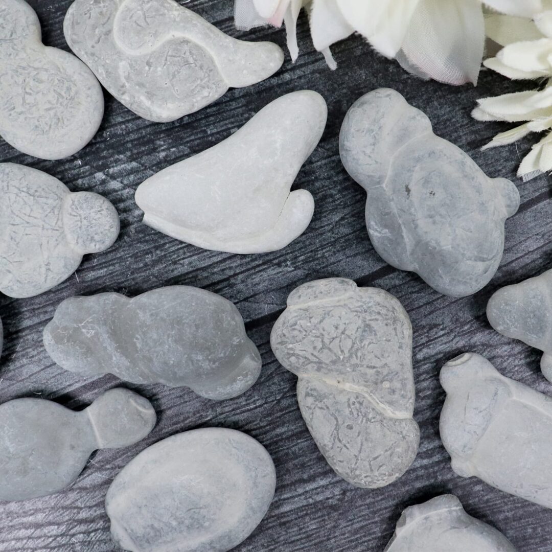 A bunch of white rocks on a table next to flowers.