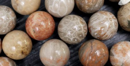 A bunch of brown and white marble beads on a table.