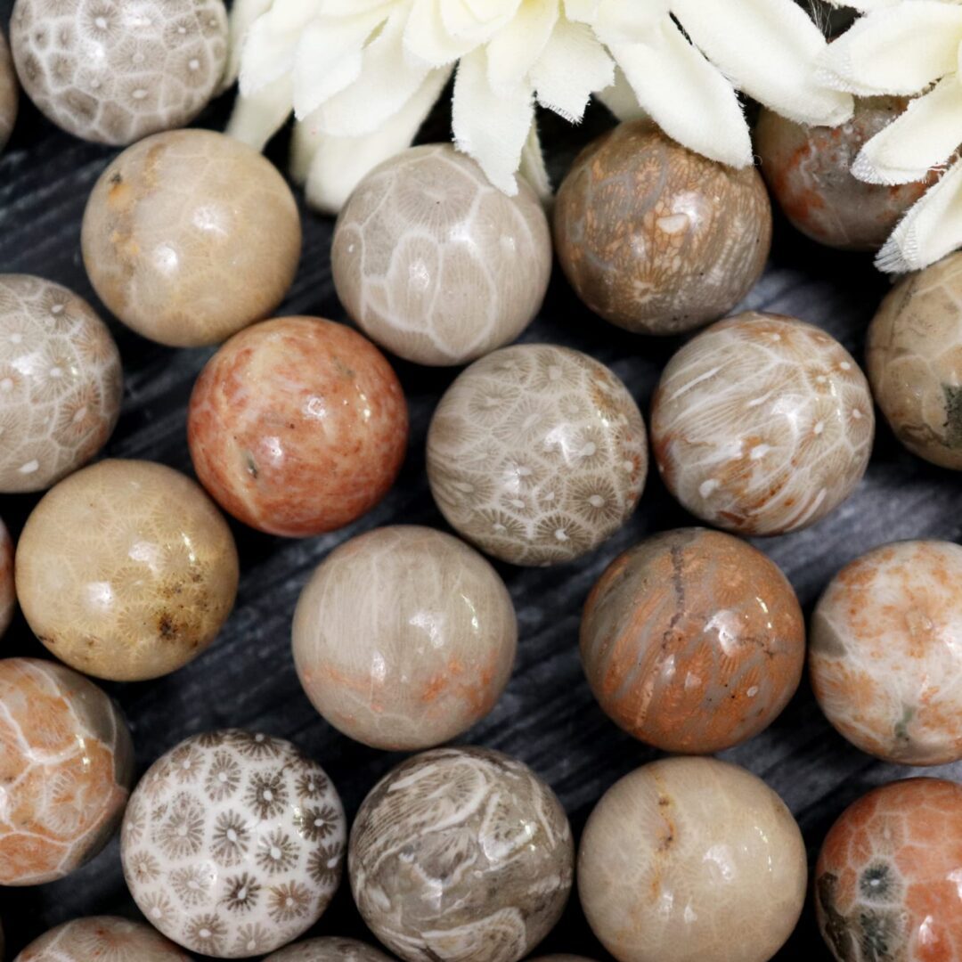 A bunch of brown and white marble beads on a table.