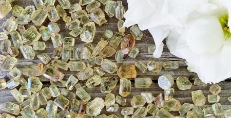 A bunch of yellow crystals on a wooden table.