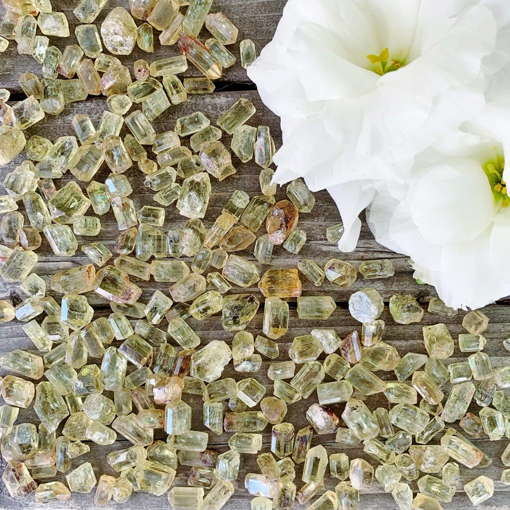 A bunch of yellow crystals on a wooden table.