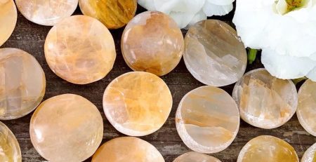 A bunch of yellow and white stones on a wooden table.