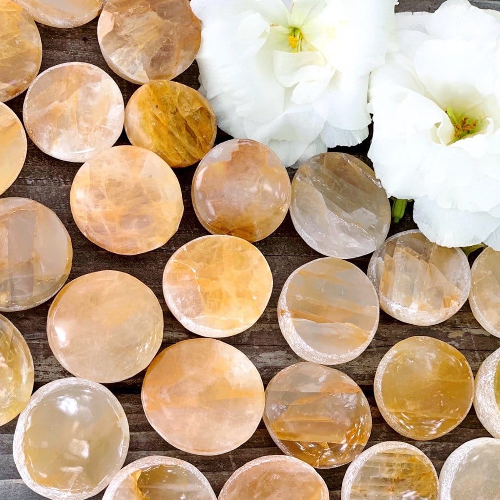 A bunch of yellow and white stones on a wooden table.