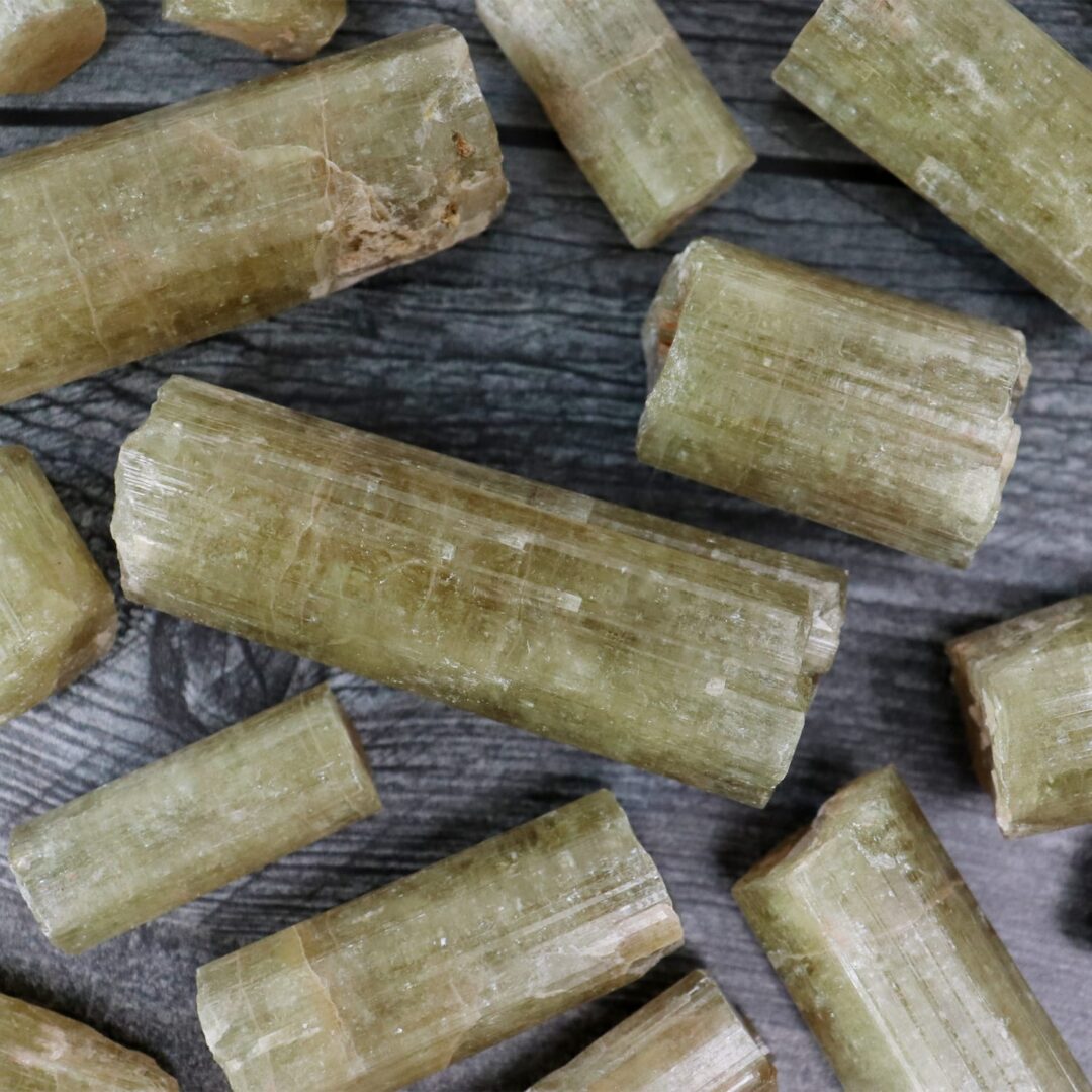 A bunch of green crystals on a wooden table.