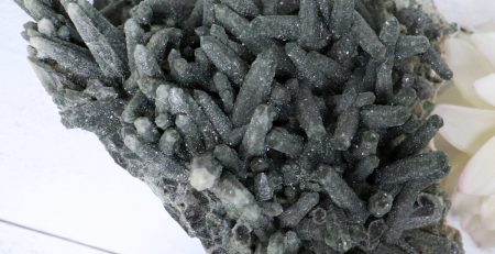 A cluster of black crystals on a white table.