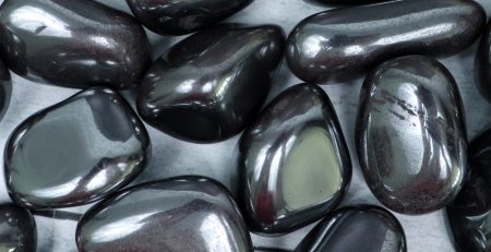 A pile of black pebbles on a metal surface.