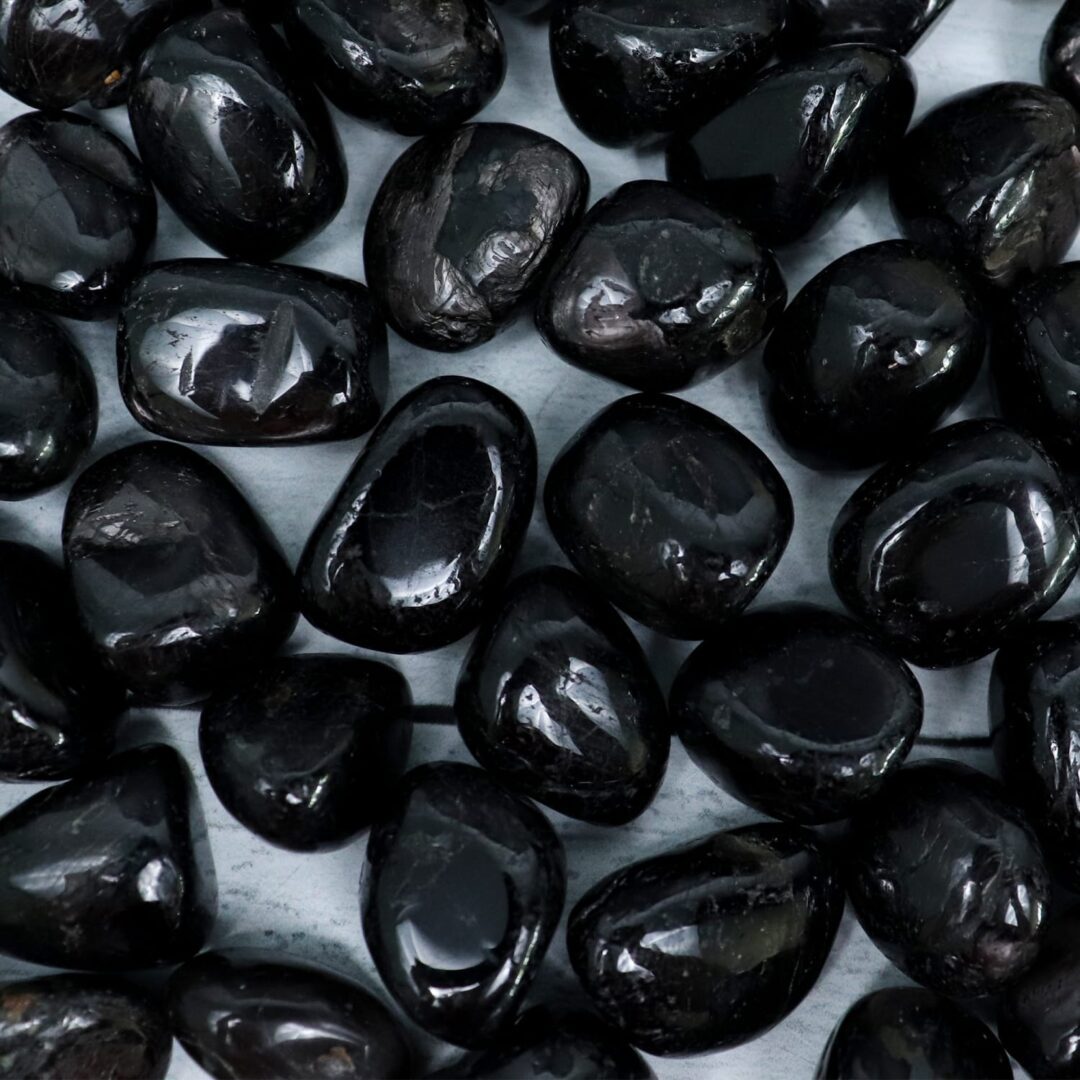 A pile of black pebbles on a white surface.