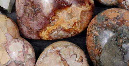 A group of heart shaped stones with flowers on them.