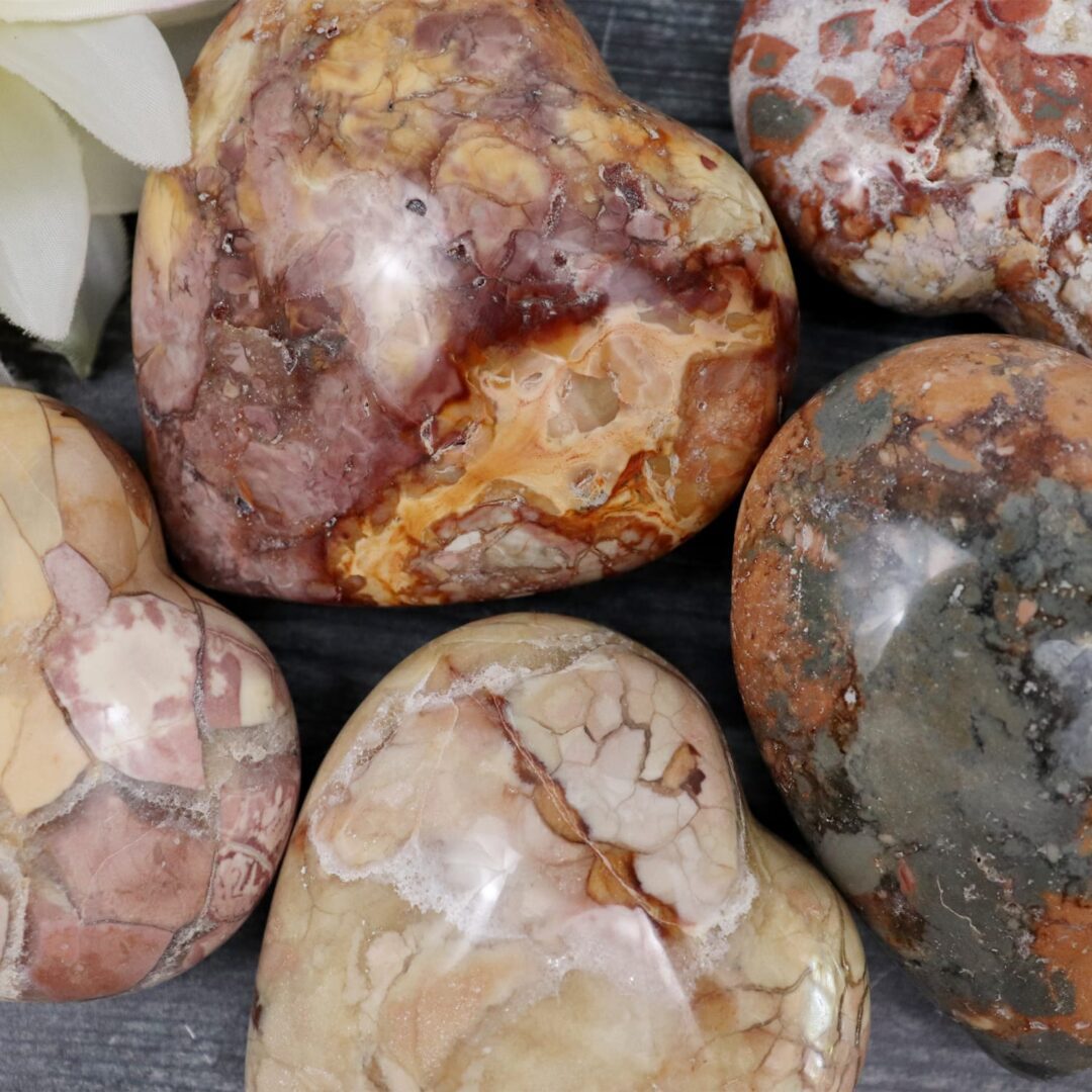 A group of heart shaped stones with flowers on them.