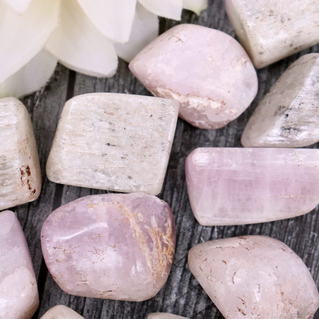 A bunch of pink and white stones on a wooden table.