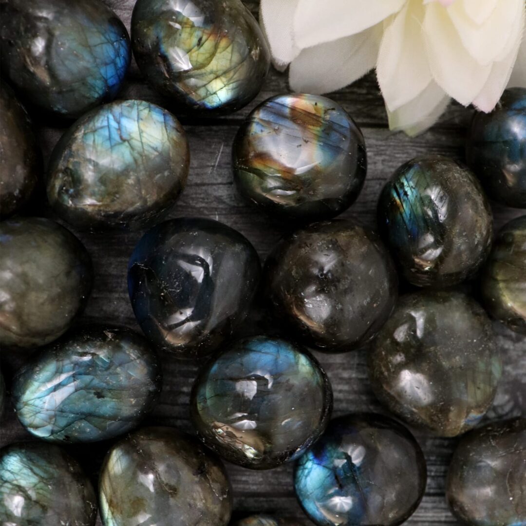 A bunch of labradorite beads on a wooden surface.