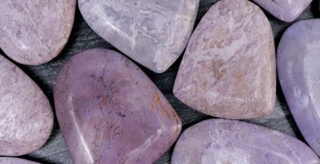 Purple amethyst stones on a wooden surface.