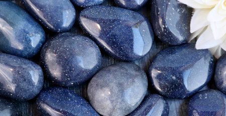 A bunch of blue stones with a flower in the middle.