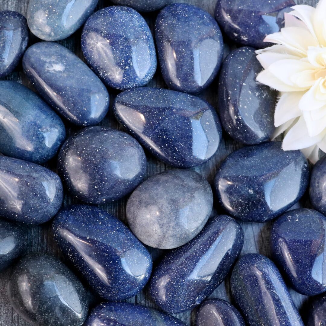 A bunch of blue stones with a flower in the middle.