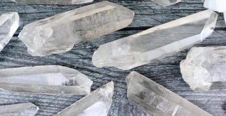 A bunch of crystal points on a wooden table.