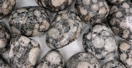 A pile of black and white stones on a white surface.