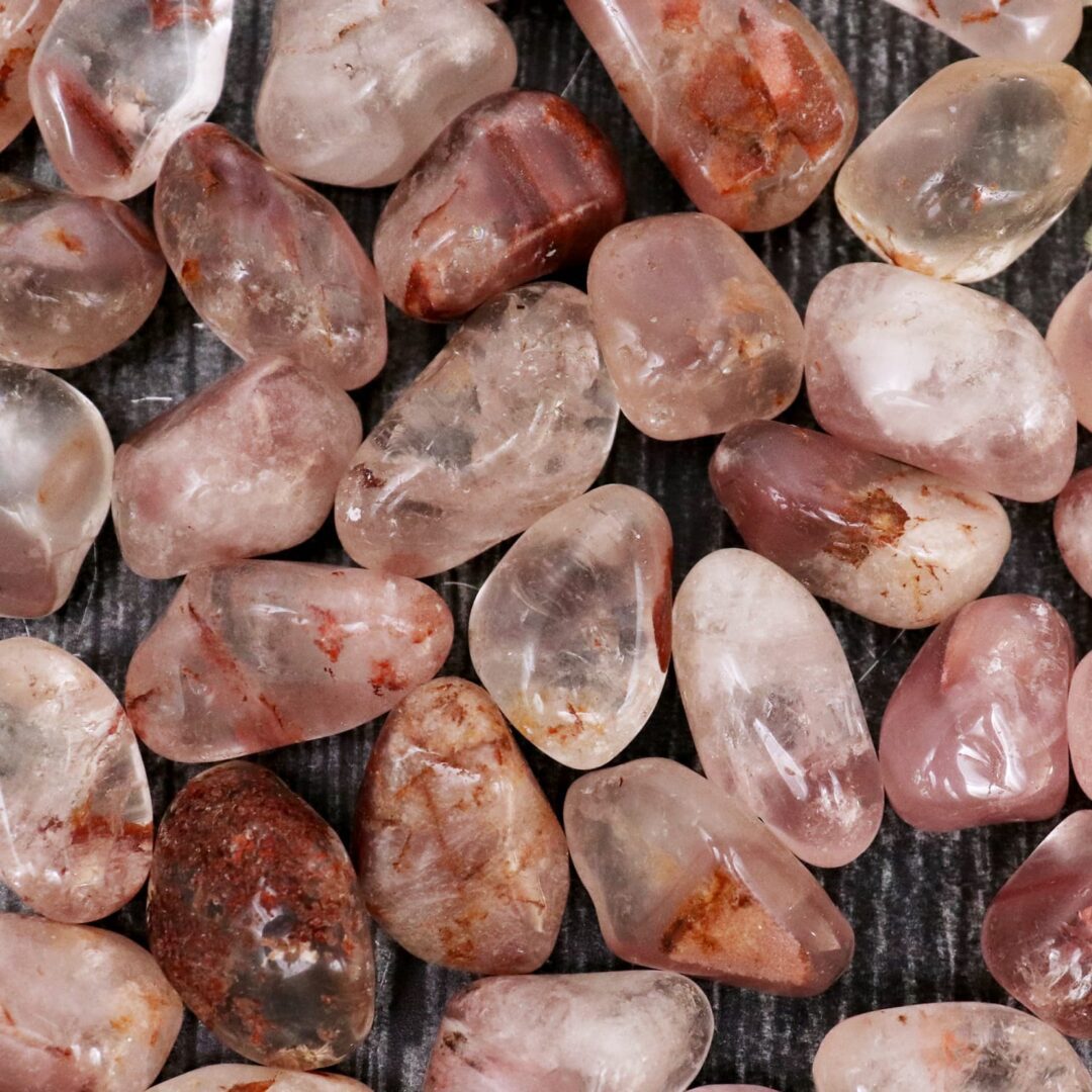 A pile of pink quartz stones on a wooden surface.