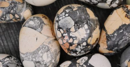 A bunch of black and white marble eggs on a table.