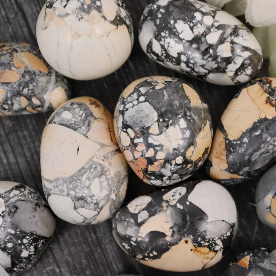 A bunch of black and white marble eggs on a table.