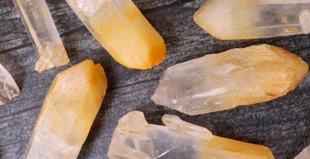 A bunch of yellow crystals on a black surface.