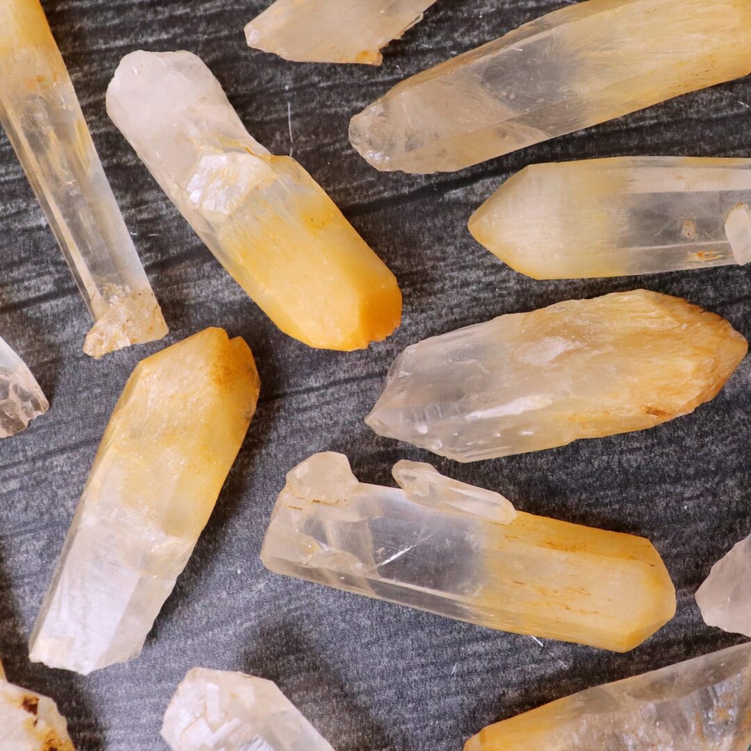 A bunch of yellow crystals on a black surface.