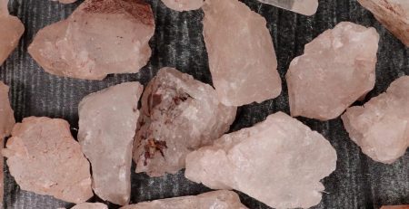 A pile of pink crystals on a wooden surface.