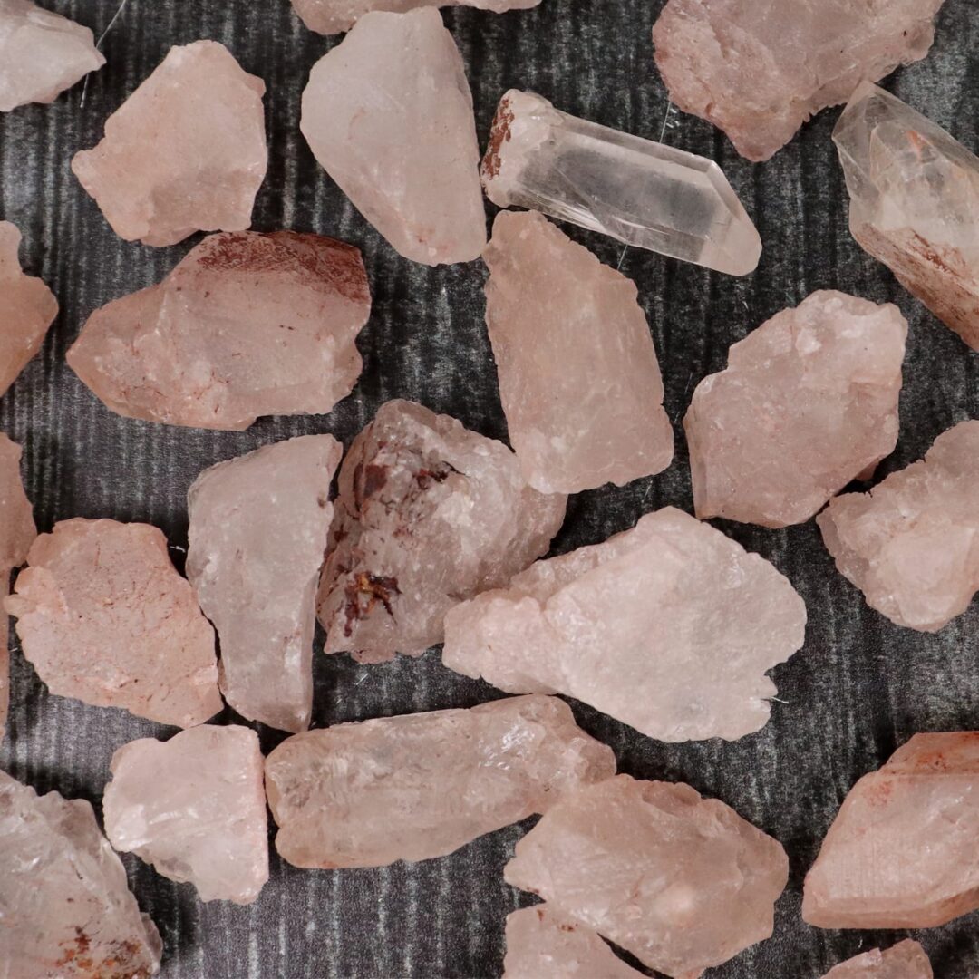 A pile of pink crystals on a wooden surface.