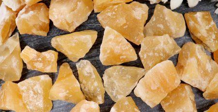 A pile of yellow crystals with a flower in the middle.