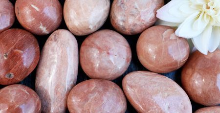 A bunch of red stones with a flower in the middle.