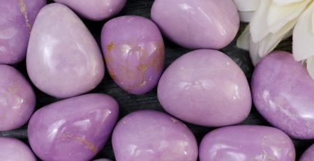 A bunch of purple stones with a flower in the middle.