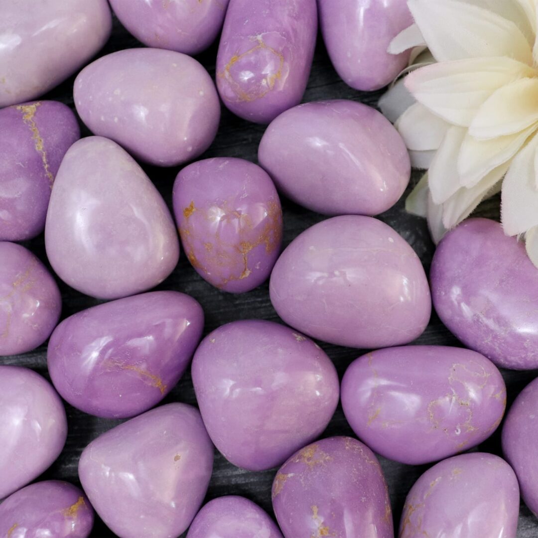 A bunch of purple stones with a flower in the middle.