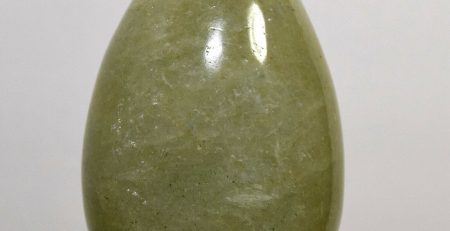 A green jade egg on a stand.