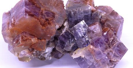 A cluster of purple and orange crystals on a white background.