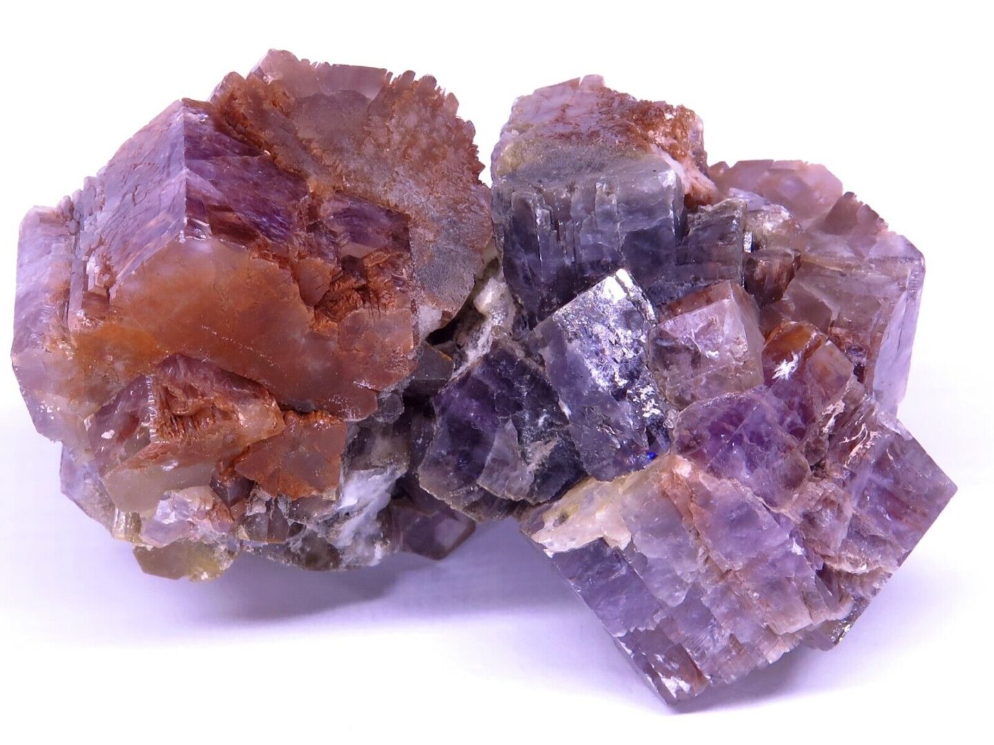 A cluster of purple and orange crystals on a white background.