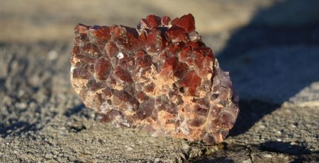 A piece of red crystal sitting on the ground.