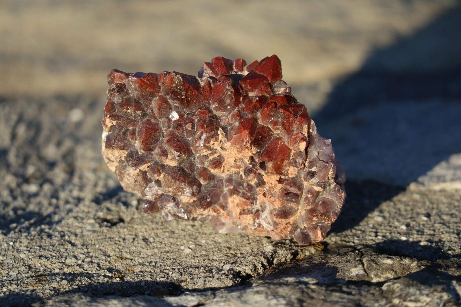 A piece of red crystal sitting on the ground.