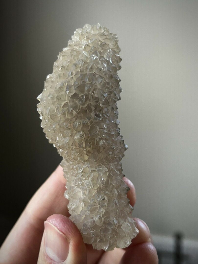 A person holding a small piece of quartz.