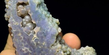 A person holding a piece of blue agate.