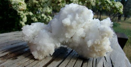 A white rock sitting on a wooden table.