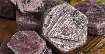 Rough rubies on a wooden table.