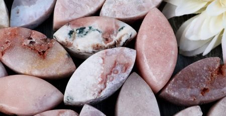 A bunch of pink and white stones with a flower in the middle.