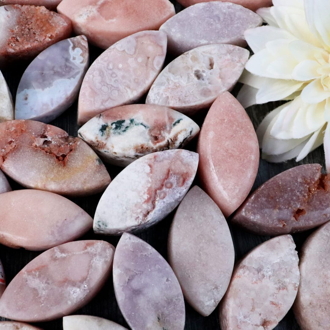 A bunch of pink and white stones with a flower in the middle.