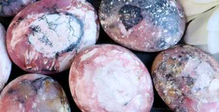 A bunch of pink and white marble eggs on a table.