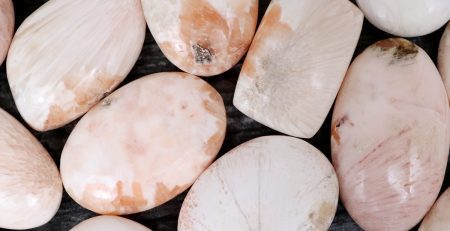 A pile of pink and white stones on a black surface.