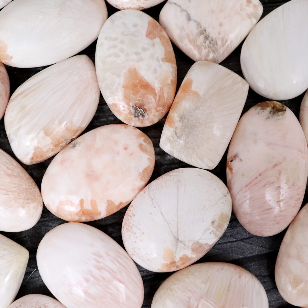 A pile of pink and white stones on a black surface.