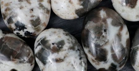 A group of black and white marble eggs on a table.